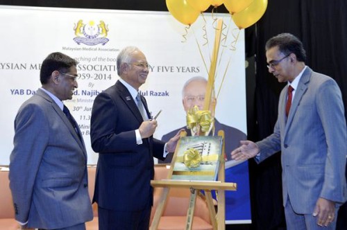 Najib launching the ‘Malaysan Medical Association Fifty Five Years 1959-2014’ book. Also seen are Subramaniam (left) and Dr Ashok Zachariah. — Bernama photo 